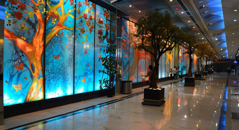 Immersive event tech setup featuring wide LED wall canvases and synchronized projection mapping inside a modern convention center.